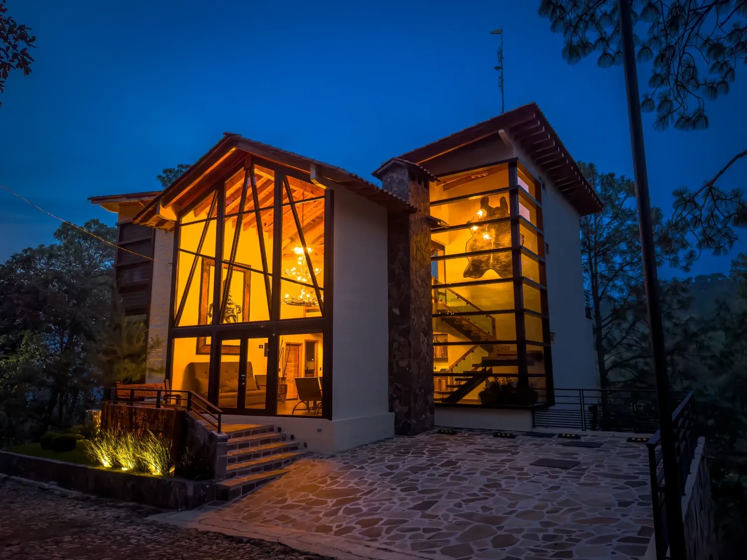 Cabaña de lujo iluminada al anochecer entre los pinos en Mazamitla