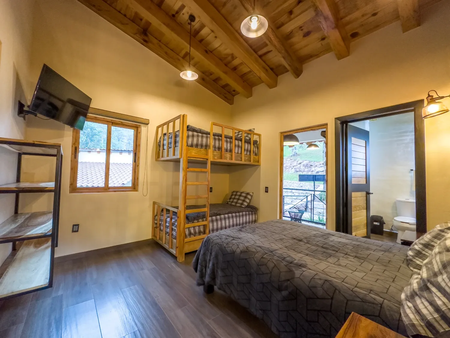 Habitación con litera y salida a la terraza con vista al bosque en la cabaña